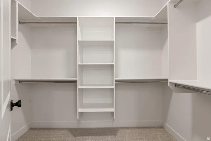 Built-in closet system with multiple shelves, hanging rods, and white finishes