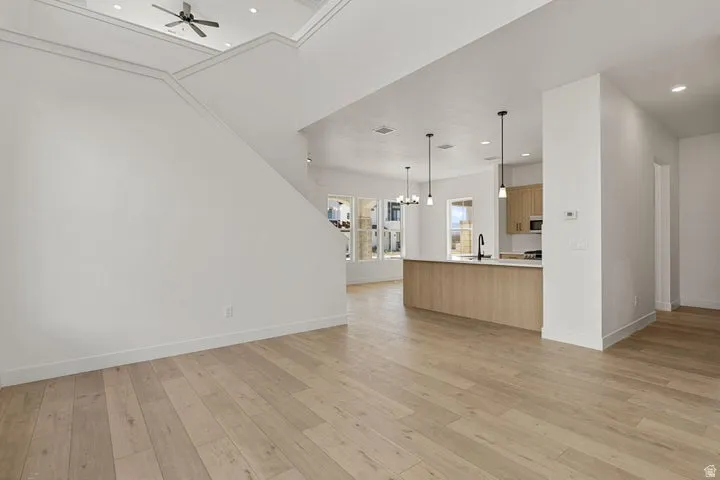 Spacious living area with wood-finish flooring, high ceilings, and recessed lighting