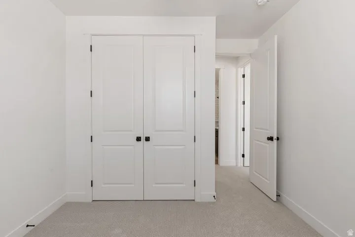 White interior doors with matte black hardware and light-colored carpet flooring
