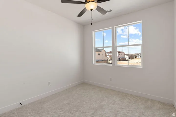 Recessed lighting, ceiling fan with integrated light, dual pane windows, and neutral carpet