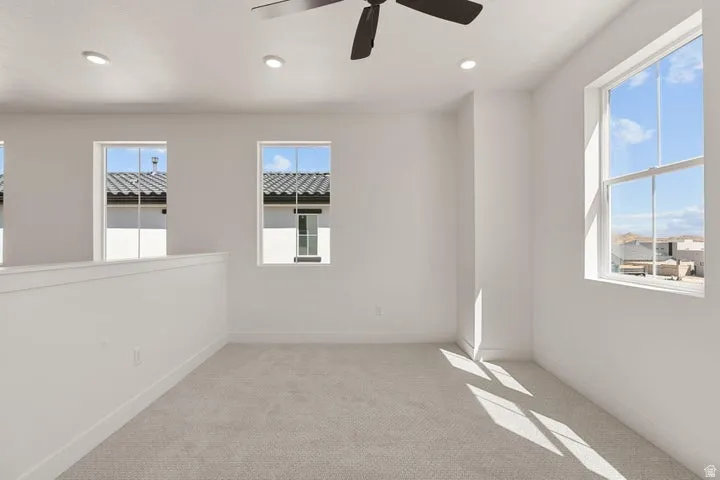 Recessed lighting, ceiling fan, white walls, carpet flooring, multiple windows