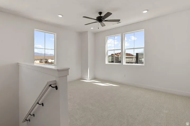 Spacious room featuring multiple windows, recessed lighting, and a ceiling fan