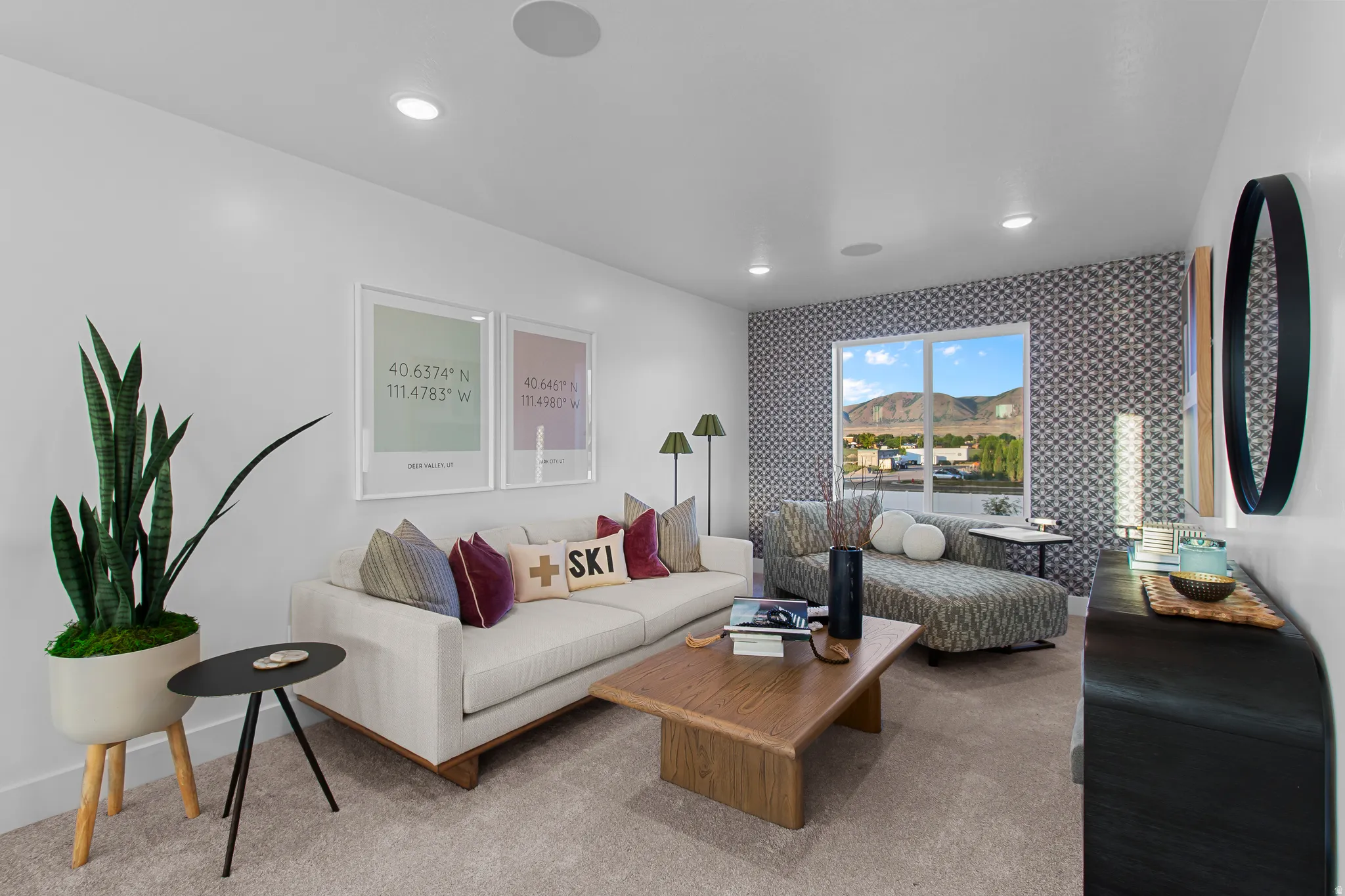 Recessed lighting, soft gray carpet, and a large window with mountain scenery