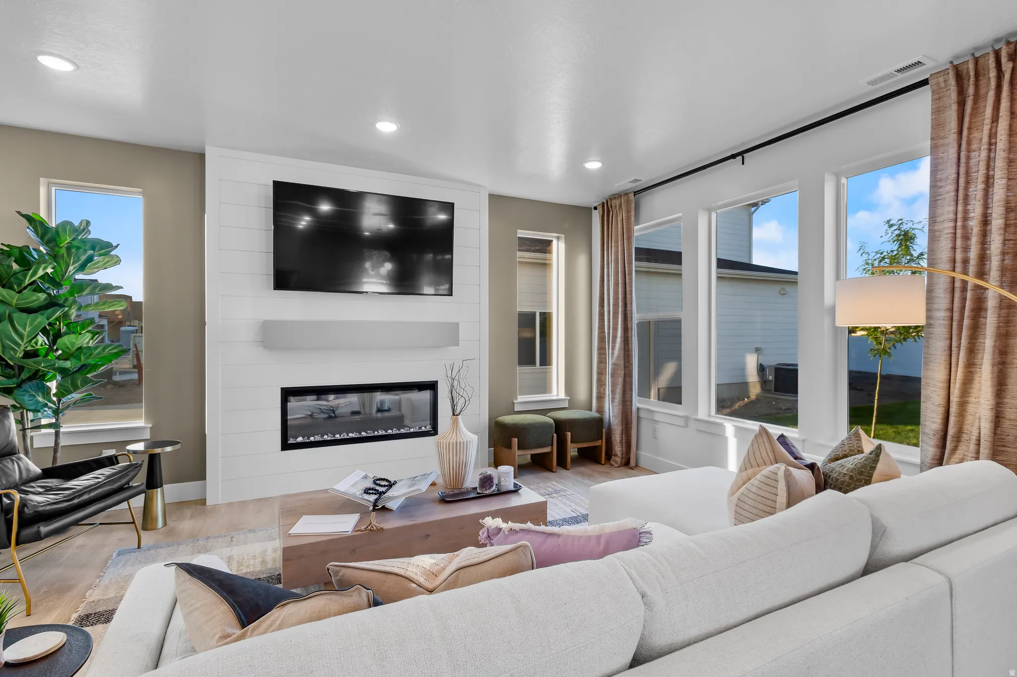 Modern living space featuring wood-finish flooring and recessed lighting
