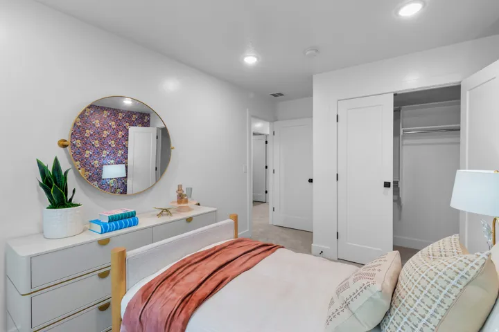 Recessed lighting illuminates the neutral wall colors and carpeted flooring