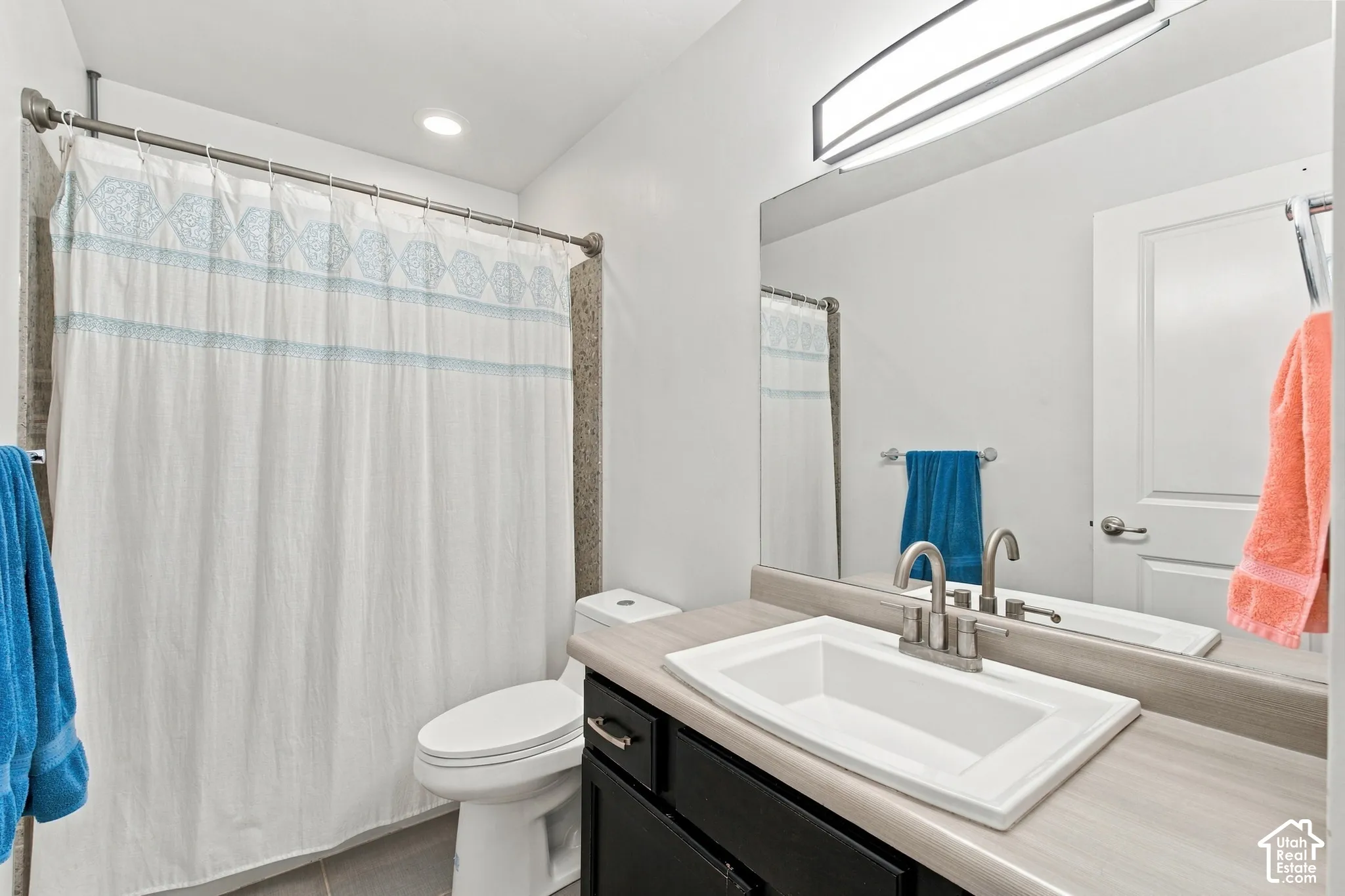 Recessed ceiling lighting, linear vanity lighting, integrated sink, brushed nickel faucet, and full-width mirror