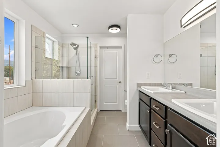 Dual vanity with integrated sinks, dark wood-finish cabinetry, and a large mirror