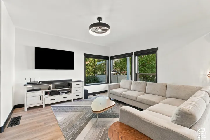 Corner window placement, wood-finish flooring, white walls, and a contemporary ceiling fixture