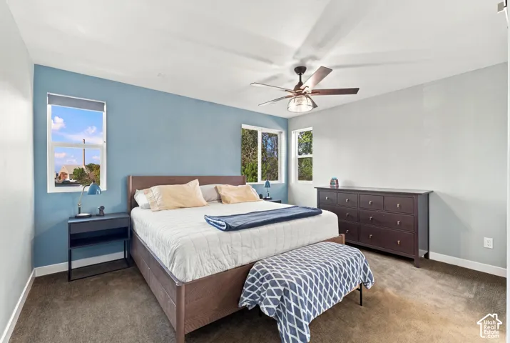 Recessed lighting, ceiling fan with light fixture, multiple windows, and carpeted flooring