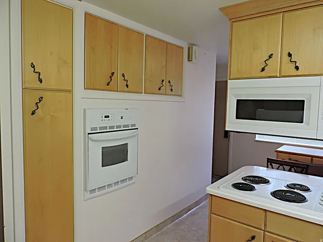 Light wood-finish cabinetry with decorative hardware