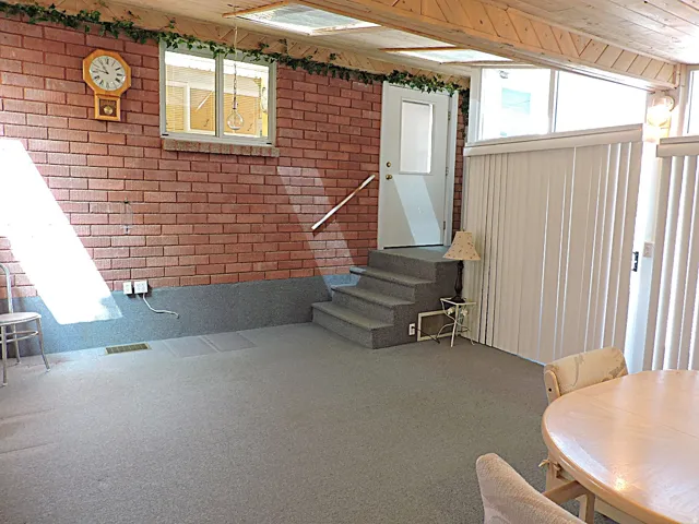 Brick accent wall with a wood-beamed ceiling