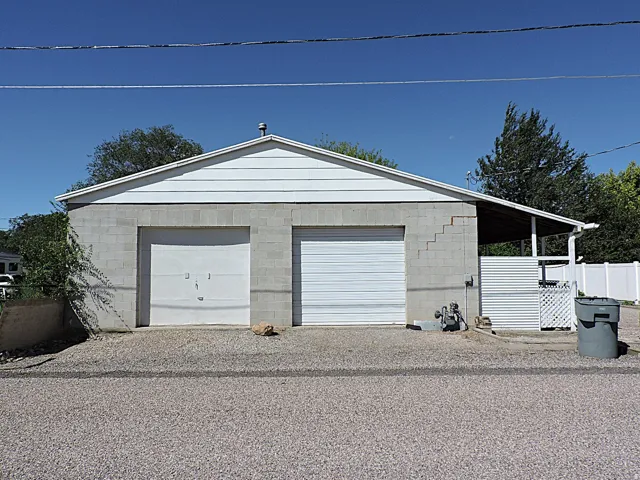Garage featuring a block exterior, horizontal siding, and an attached covered patio