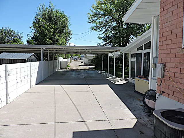 Expansive concrete driveway with a covered carport