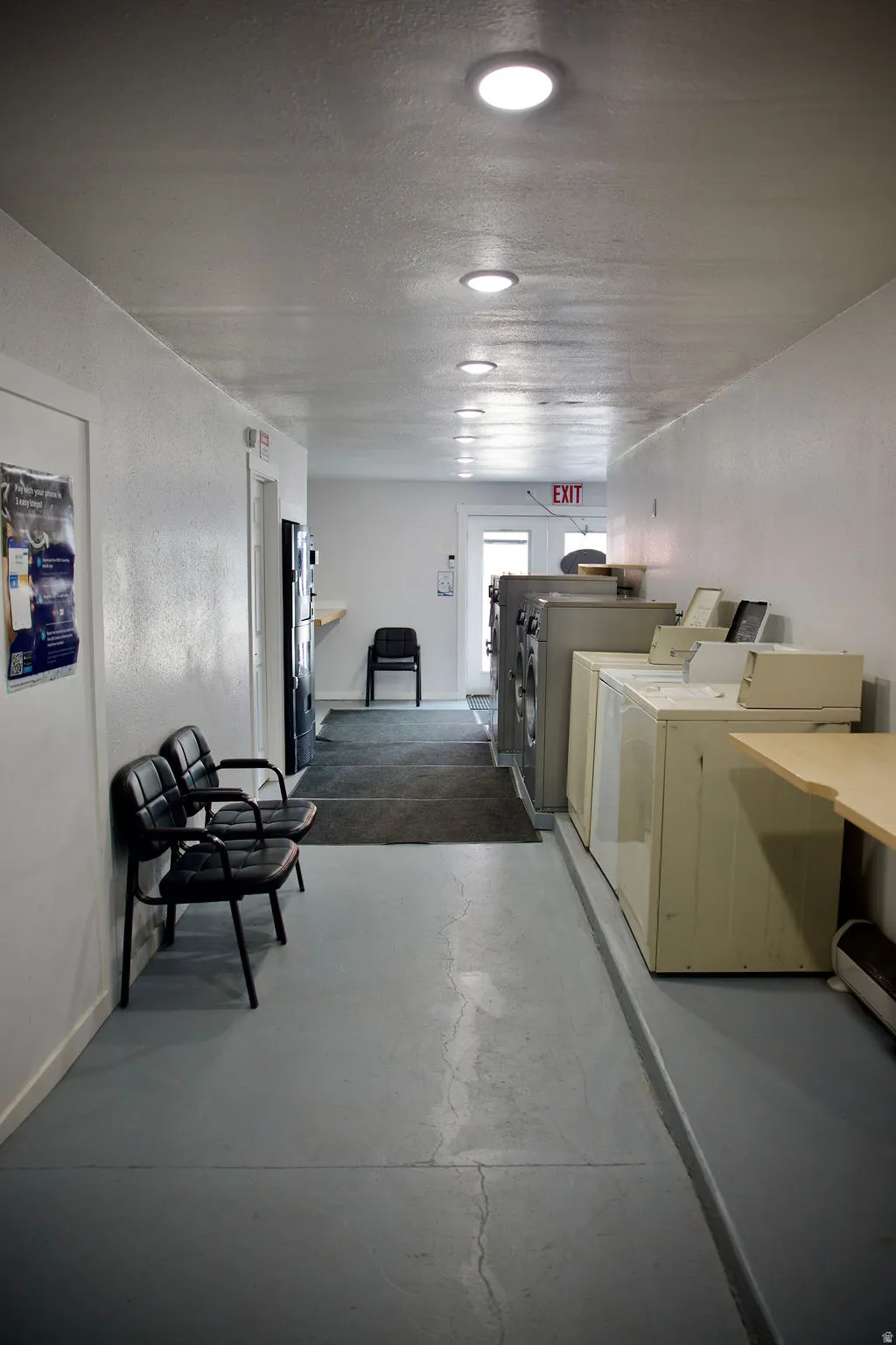 Modern commercial corridor featuring polished concrete flooring, recessed ceiling lighting, and clean white wall finishes