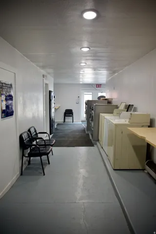 Modern commercial corridor featuring polished concrete flooring, recessed ceiling lighting, and clean white wall finishes