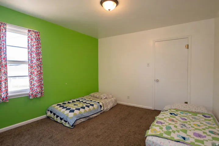 Recessed window with white trim, wall-mounted light fixture, and brown carpet flooring