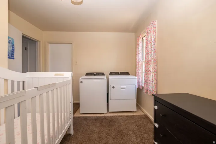 Laundry area with a side-by-side washer and dryer, window, and neutral wall paint