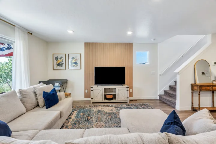 Wood-finish flooring, recessed lighting, and a slatted accent wall create a welcoming atmosphere