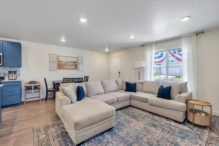Open-concept living space with recessed lighting, wood-finish flooring, and a dining area with built-in bench seating