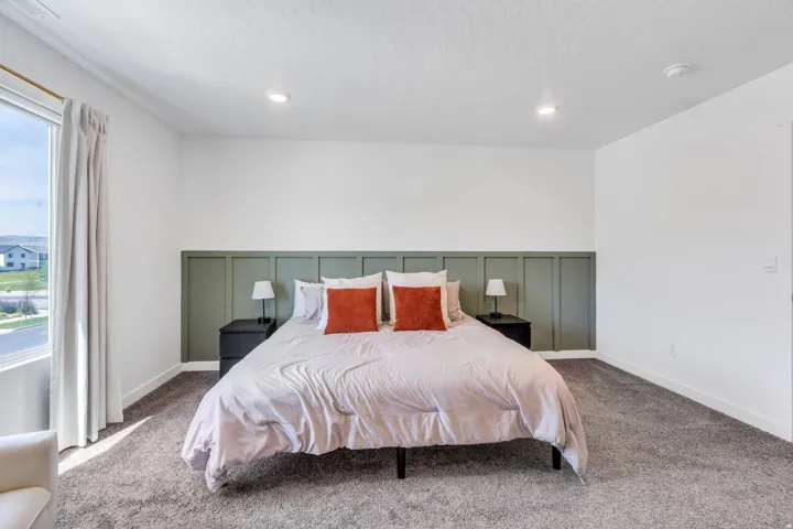 Expansive window, recessed lighting, accent wall paneling, and wall-to-wall carpeting