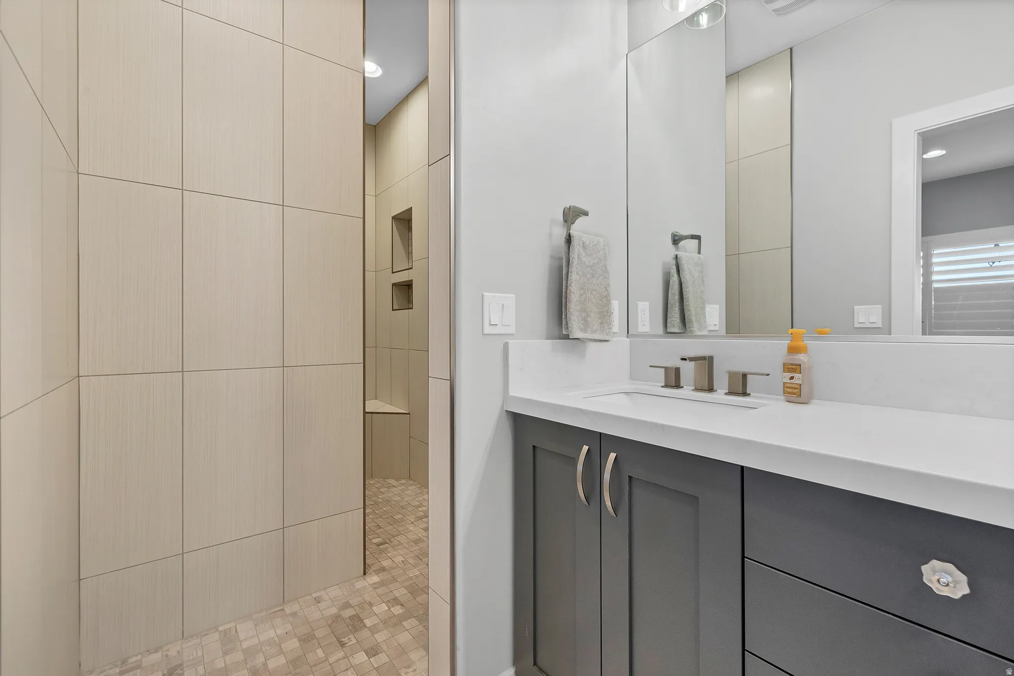 Wall-mounted vanity with a rectangular undermount sink, countertop, and brushed nickel faucet