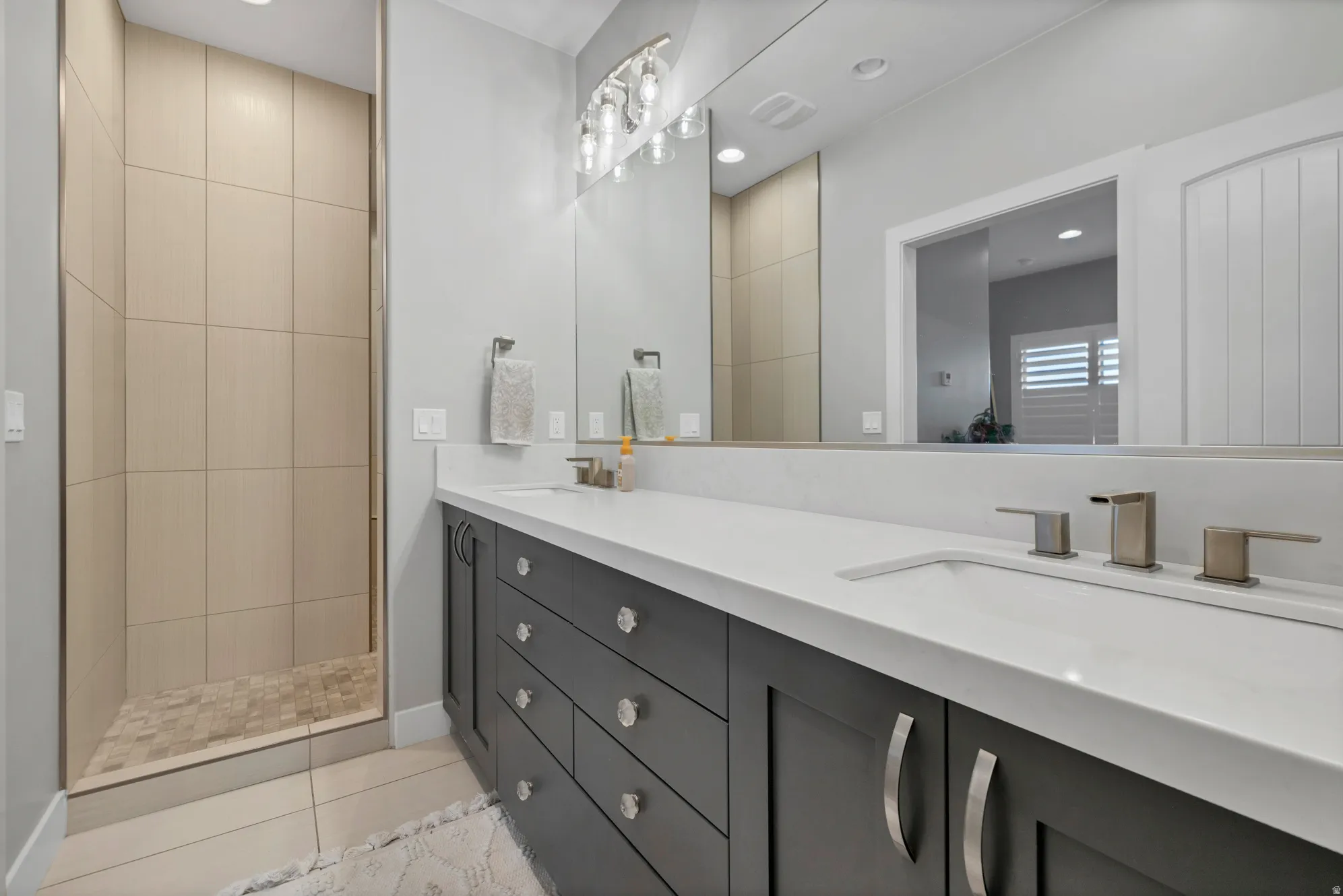 Dual vanity with integrated sinks, brushed nickel fixtures, and dark cabinetry