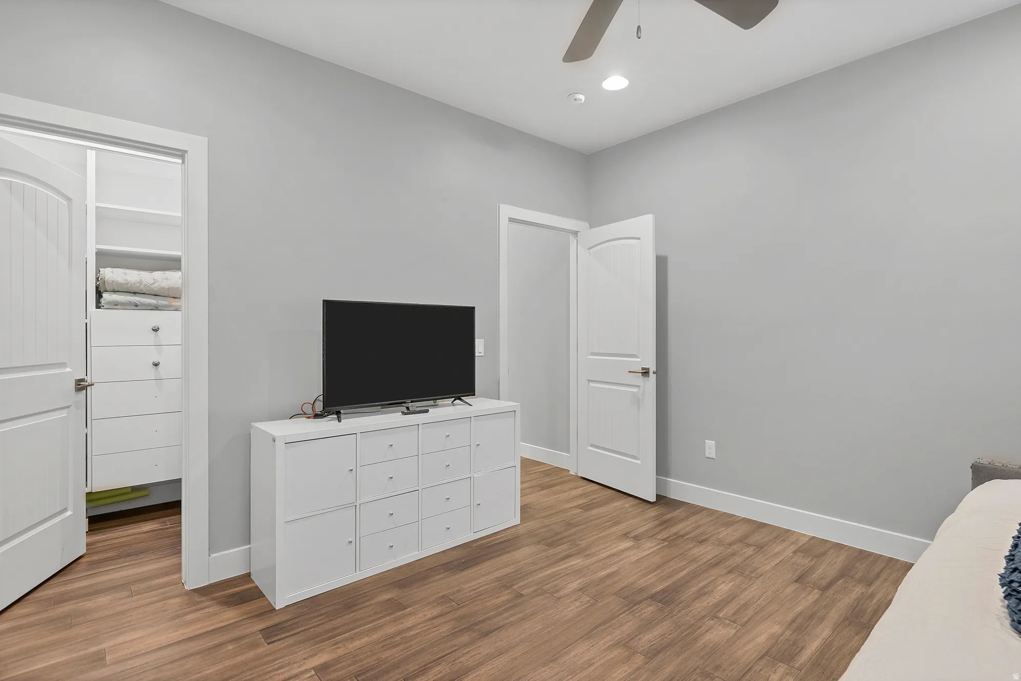 Wood-finish flooring, recessed lighting, ceiling fan, and a built-in closet organization system