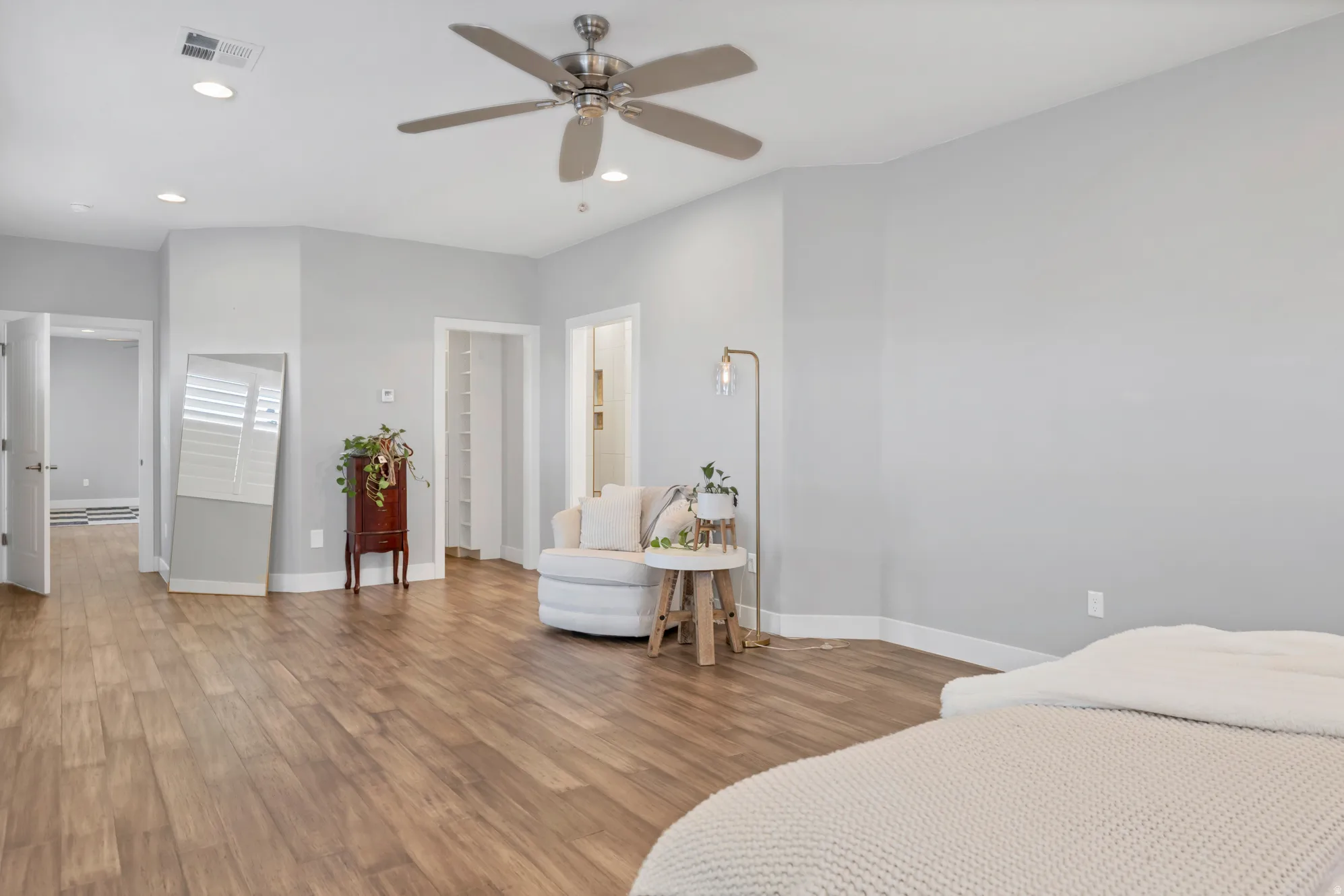 Spacious room featuring wood-finish flooring, recessed lighting, and a ceiling fan