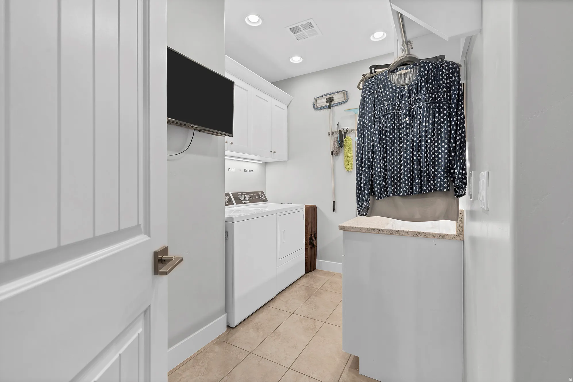 Built-in cabinetry, recessed lighting, tile flooring, and a countertop with an integrated sink