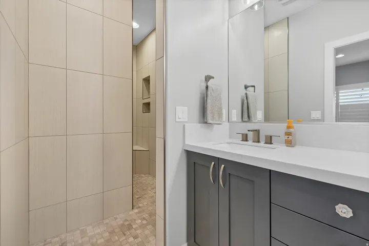 Wall-mounted vanity with a rectangular undermount sink, countertop, and brushed nickel faucet