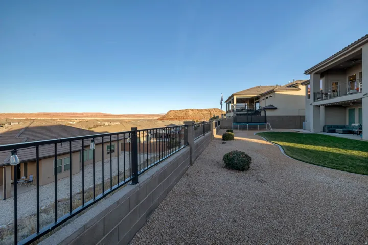 Expansive backyard featuring a manicured lawn, gravel landscaping, and mature shrubbery