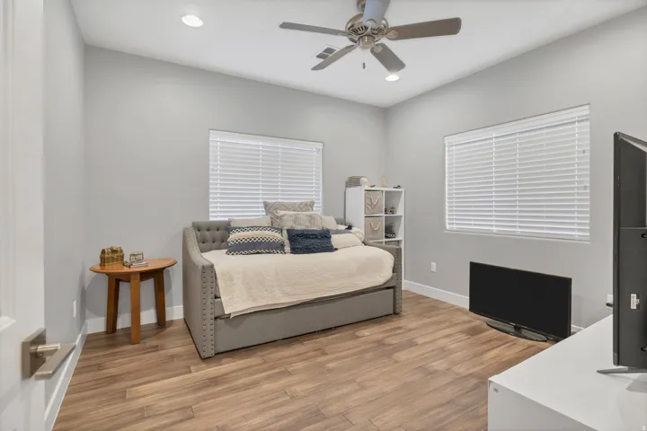 Recessed ceiling lighting, wood-finish flooring, ceiling fan with integrated lighting, window with blinds, and white baseboards
