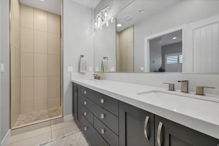 Dual vanity with integrated sinks, brushed nickel fixtures, and dark cabinetry