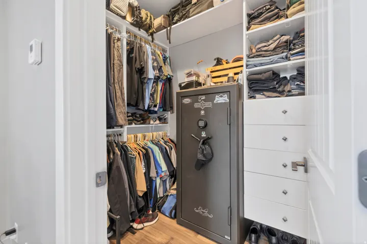 Custom closet organization system with integrated shelving, multiple hanging rods, and built-in drawers featuring decorative pulls
