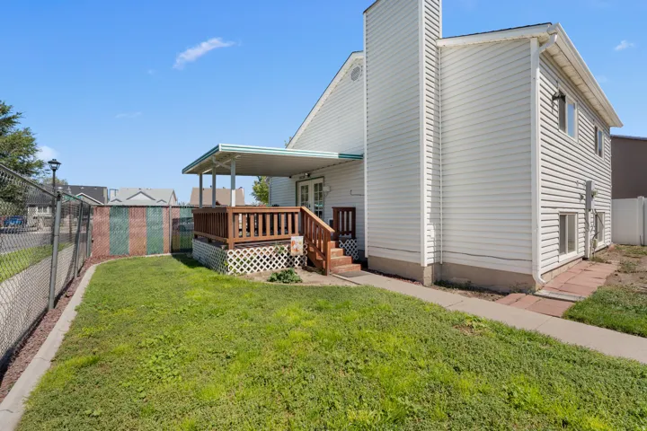 Covered deck with wood railing, white lattice skirting, and direct access to the interior