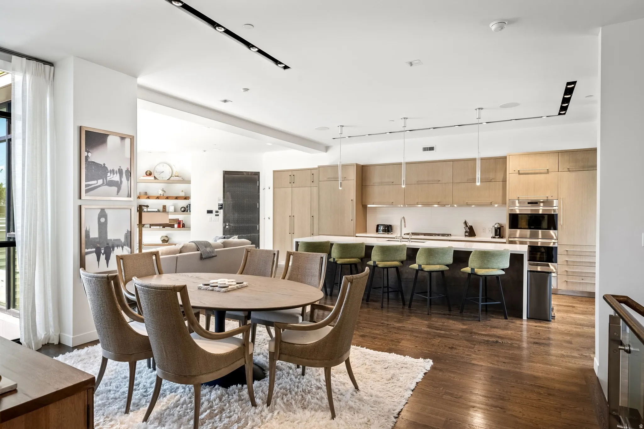 Spacious open-concept living area featuring wood-finish flooring, recessed lighting, and a large kitchen island with integrated seating