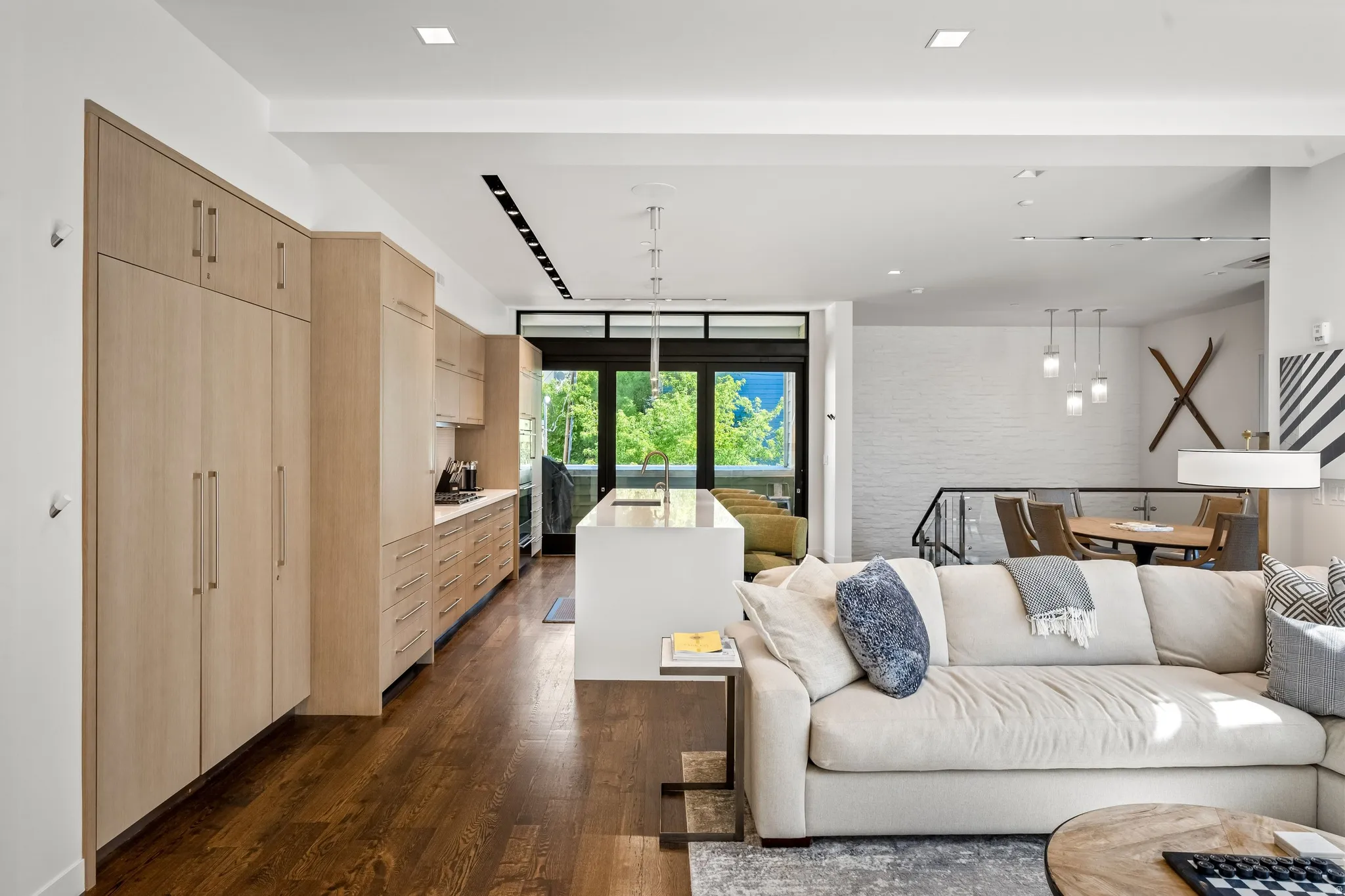 Open-concept living area with dark wood-finish flooring, white walls, and recessed lighting