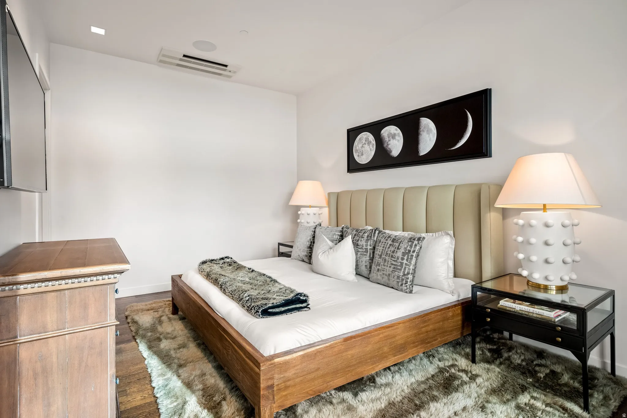 Wood-finish flooring, recessed lighting, and a ceiling-mounted speaker