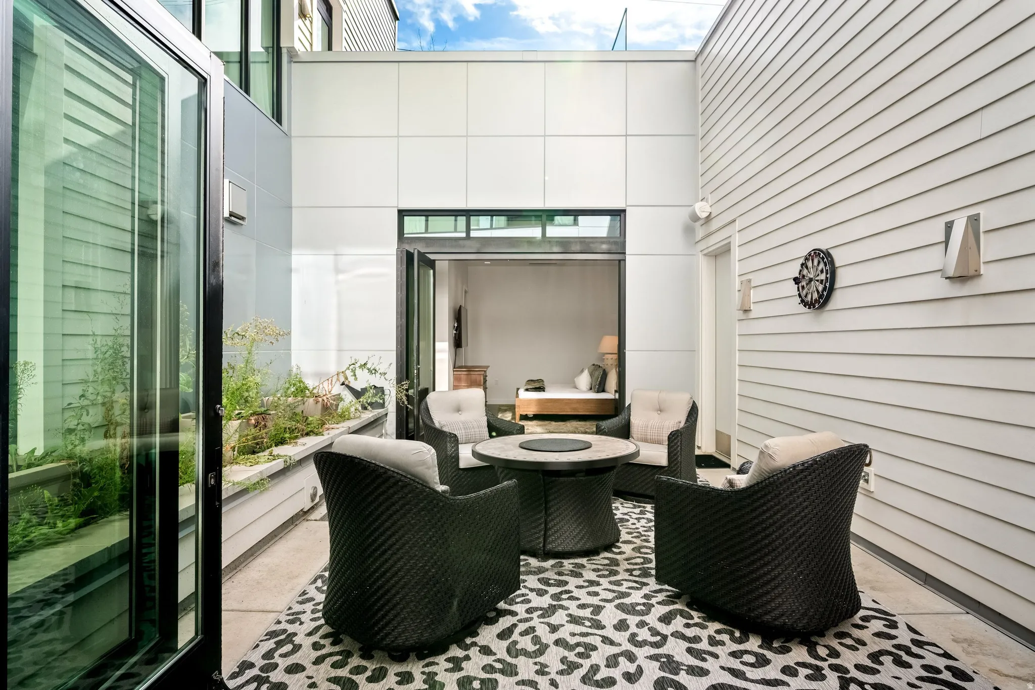 Private courtyard featuring a sliding glass door, a built-in planter, and exterior wall lighting