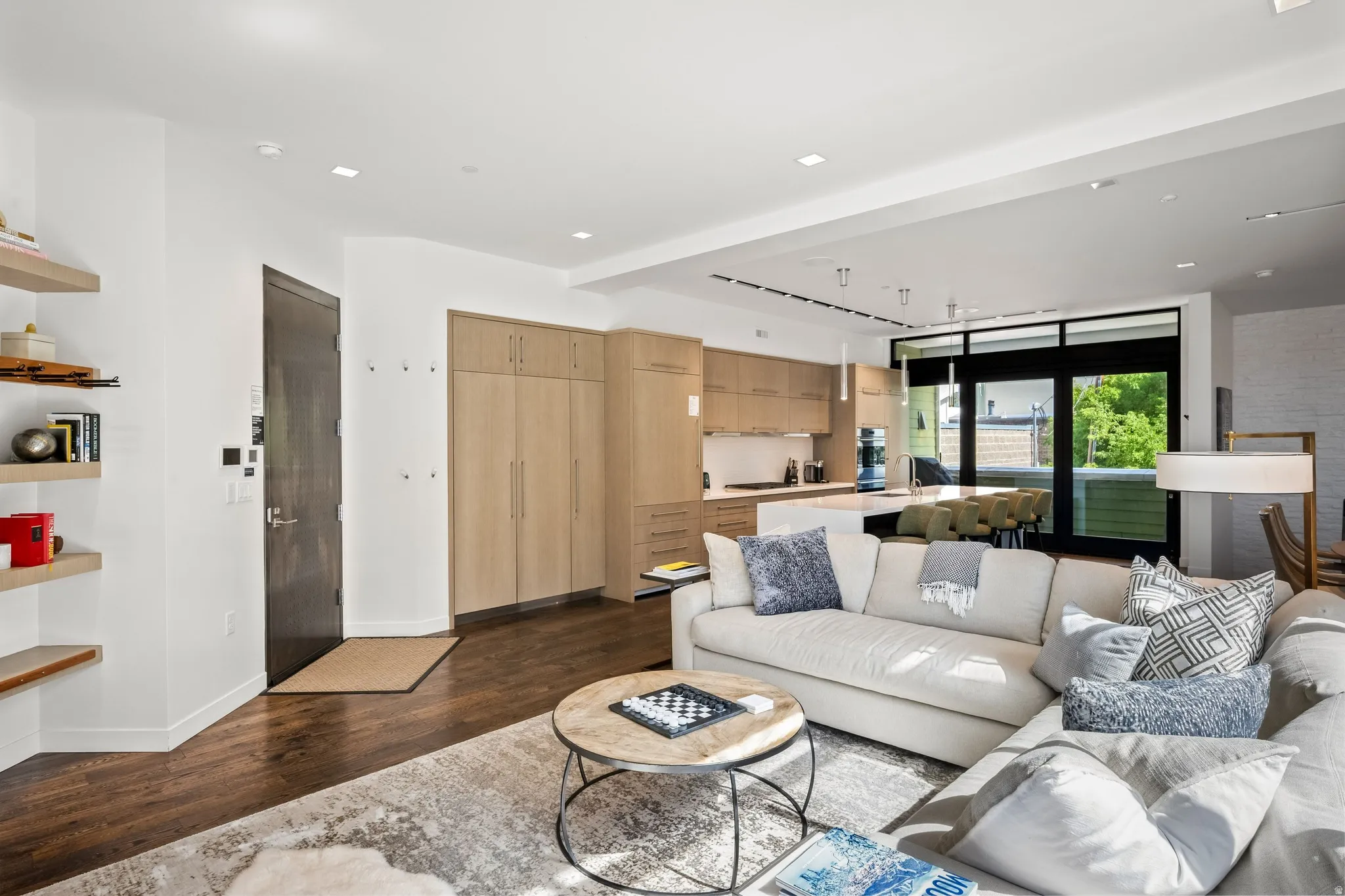 Recessed lighting, wood-finish flooring, custom built-in cabinetry, kitchen island with counter seating, and sliding glass doors