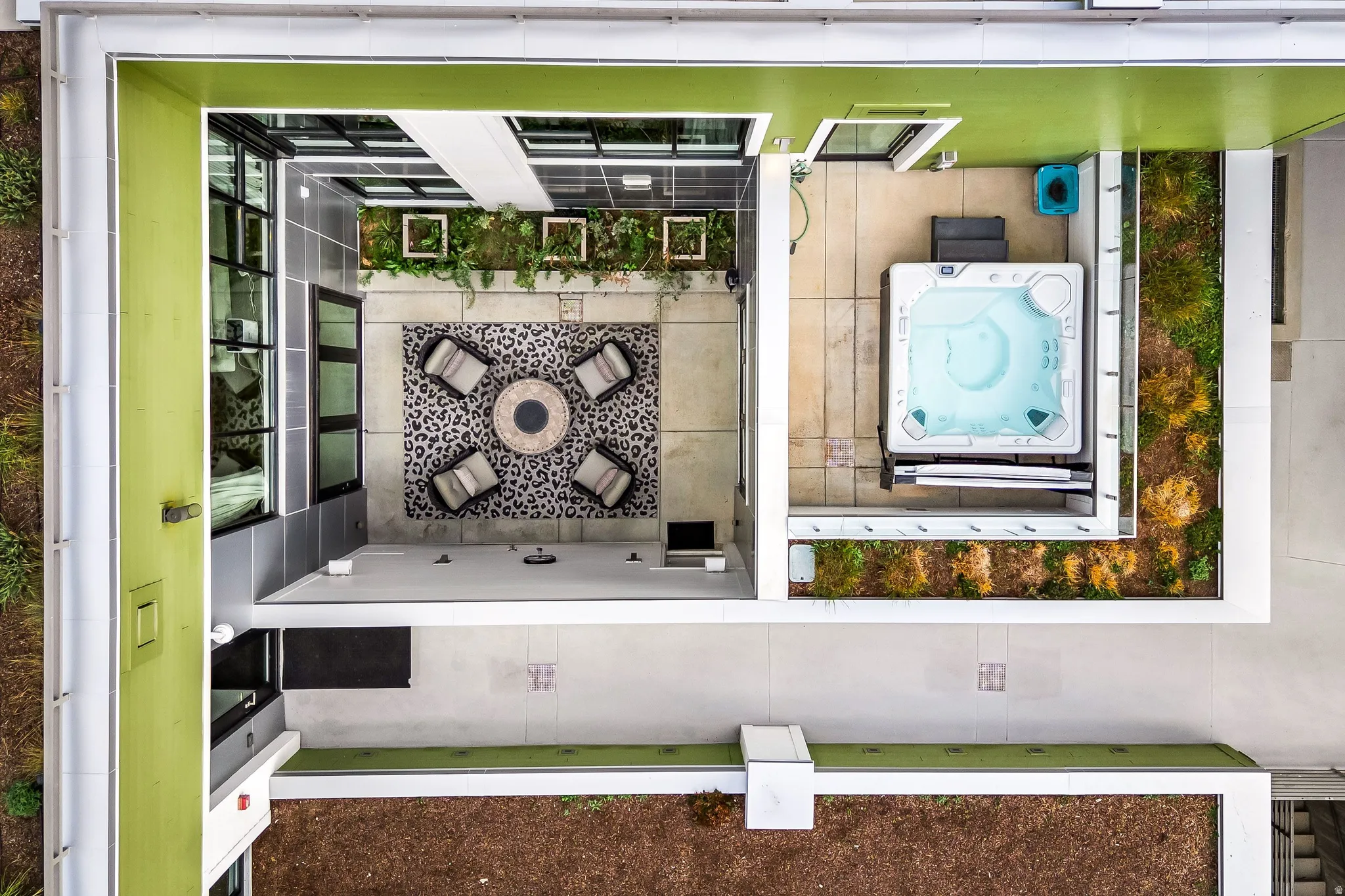 Outdoor patio featuring a hot tub, concrete surfaces, and green space