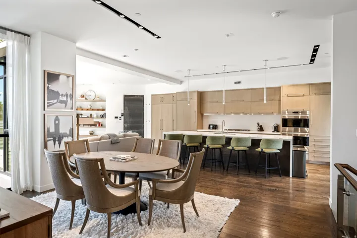 Spacious open-concept living area featuring wood-finish flooring, recessed lighting, and a large kitchen island with integrated seating