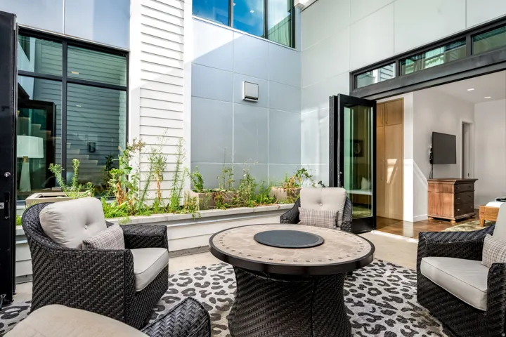 Outdoor patio featuring a built-in planter, large glass panel doors, and modern exterior siding