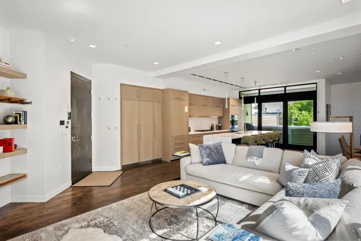 Recessed lighting, wood-finish flooring, custom built-in cabinetry, kitchen island with counter seating, and sliding glass doors