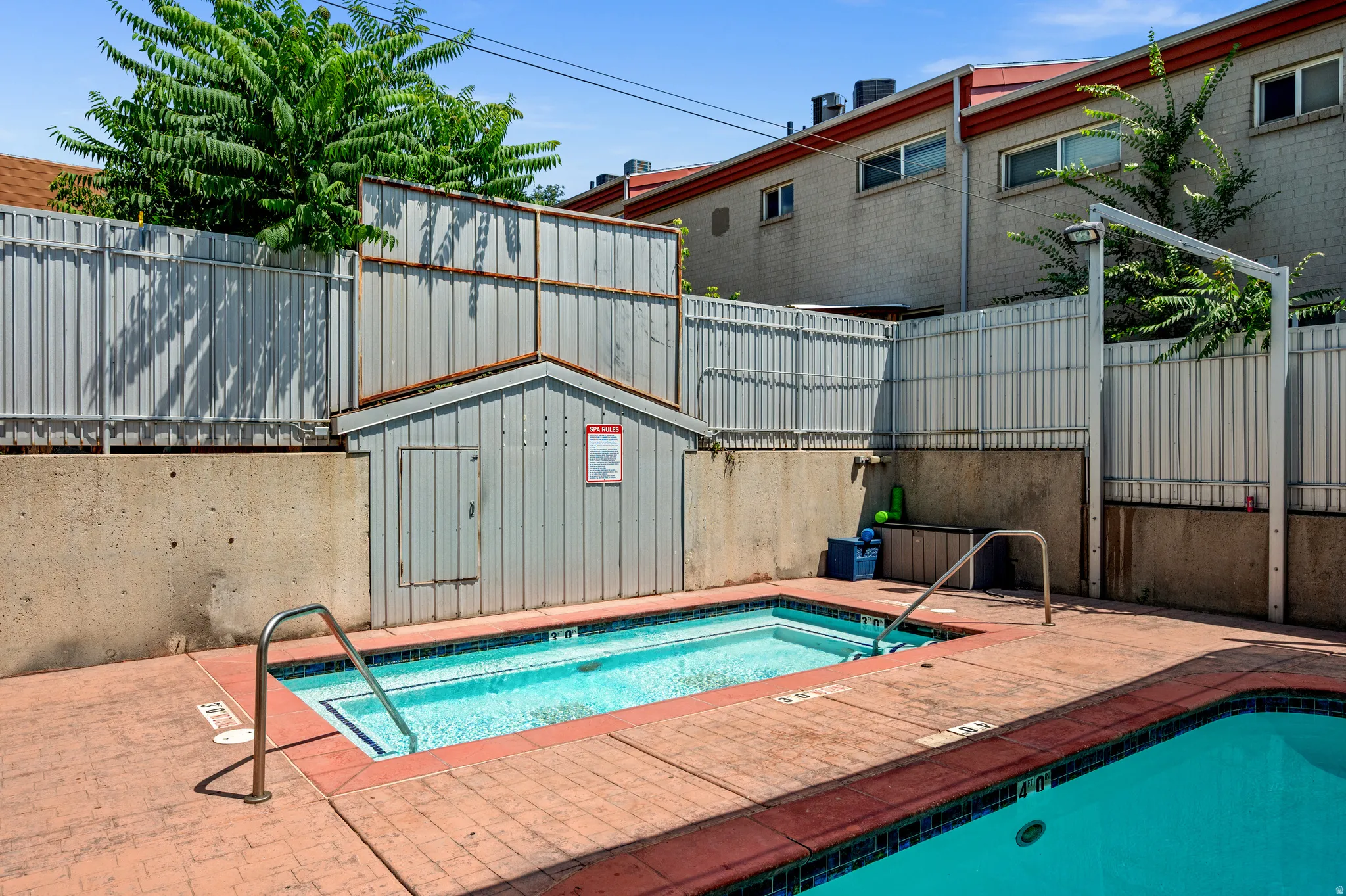 Swimming pool with integrated spa and surrounding concrete patio