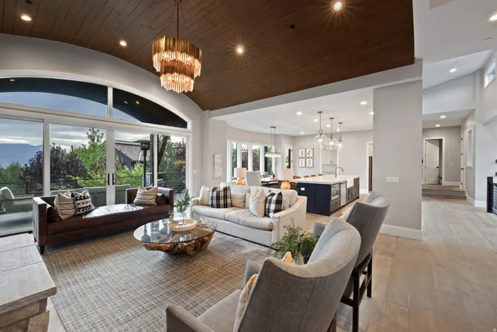 Arched ceiling with wood-finish paneling, large sliding glass doors, contemporary chandelier, recessed lighting, and light wood-finish flooring