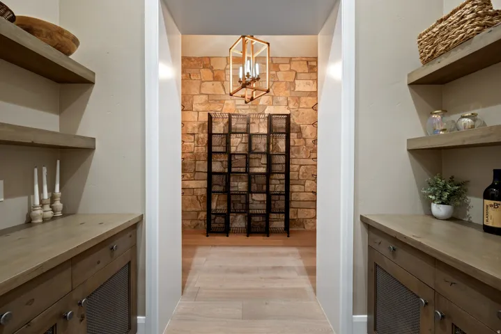 Custom cabinetry with wire mesh door inserts, wood-finish countertops, and open shelving