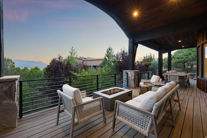 Expansive covered deck featuring wood-finish decking and a built-in fire pit
