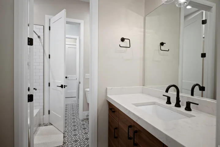 Vanity with wood-finish cabinetry, white countertop, and integrated rectangular sink