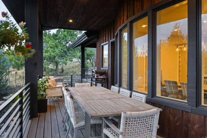 Expansive outdoor deck featuring wood-finish flooring, dark wood ceiling, and metal railings